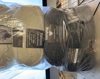 May include: Two skeins of Patons Canadiana yarn, one white and one gray. The white skein is labeled "Patons Canadiana 3.5 oz / 100g 100% acrylic / acrylique / acrílico"
