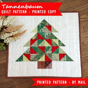 Puede incluir: Un patrón de acolchado impreso para una colcha de árbol de Navidad. El patrón se llama "Tannenbaum" y presenta un diseño de patchwork verde y rojo. El patrón está disponible para su compra por correo.