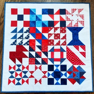May include: A red, white, and blue patchwork quilt with a variety of patterns, including stars, stripes, and polka dots.