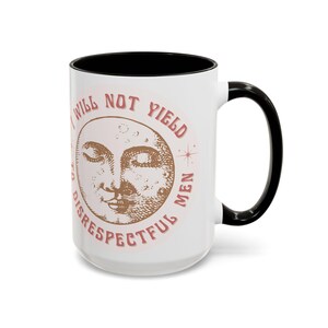 Puede incluir: Taza de cerámica blanca con interior y asa negros. La taza presenta un diseño con una cara de luna creciente y el texto "I WILL NOT YIELD TO DISRESPECTFUL MEN" en un círculo, en color marrón rojizo.