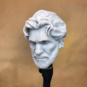 Op de afbeelding: Een 3D-geprint, ongeverfd, grijs plastic hoofdbeeld van een man met een baard en golvend haar.
