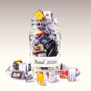 May include: A glass jar filled with small books, with some scattered around. The jar has a label reading "Read 2026". The books are in various colours and sizes. The image suggests a reading goal for the year 2026.