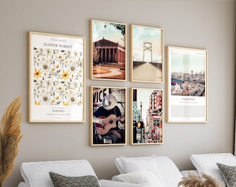 May include: A set of six framed prints featuring various scenes of Nashville, Tennessee. The prints are arranged in a grid pattern on a light beige wall above a white sofa. The prints include a floral design, a cityscape, a bridge, a building, and a musician playing a guitar.