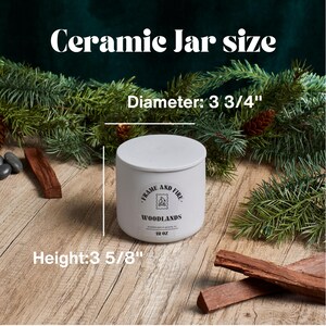 May include: White ceramic jar candle with a black label that reads "Frame and Fire Woodlands 12 oz". The jar is 3 3/4 inches in diameter and 3 5/8 inches tall.