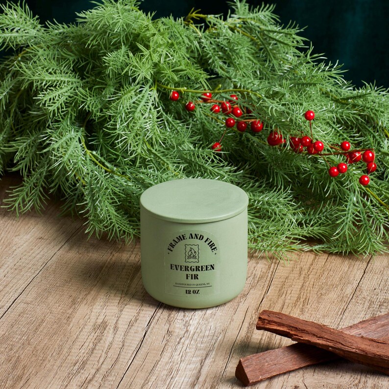 Frame and Fire luxury candles in ceramic jars with lids, featuring scents like Rosewood Lux, Saffron Noir, Cedarwood & Pine, Evergreen Fir, and Woodlands. Hand-poured coconut apricot wax candles styled with holiday decor, perfect for gifting or home