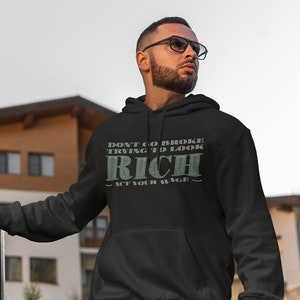 May include: A black hoodie with a green print that says "Don't go broke trying to look rich - Act your wage - "