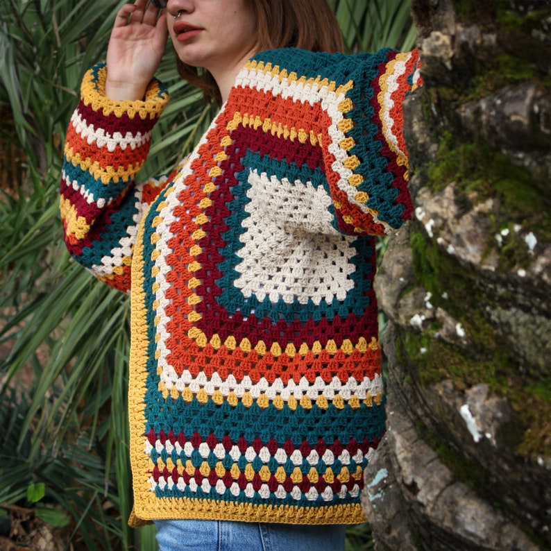 May include: A colorful crochet cardigan with a multi-colored geometric pattern in shades of red, orange, yellow, green, and white.