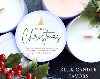 May include: White and peach-colored candles in round tins with wooden wicks. The lids feature a gold Christmas tree and the words "Merry Christmas." Text reads "May the spirit of Christmas bring you hope, love and happiness. Love, The Wilson's."