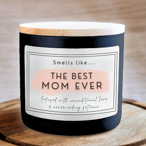 May include: Black candle with a white label that reads "Smells like... THE BEST MOM EVER Infused with unconditional love & never-ending patience".