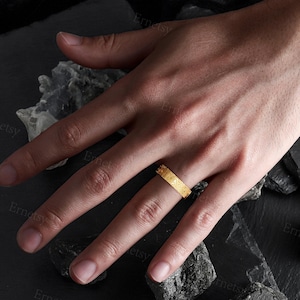 a person's hand with a ring on it