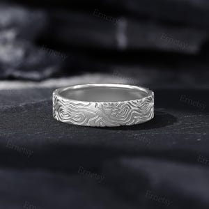 a close up of a wedding ring on a black surface