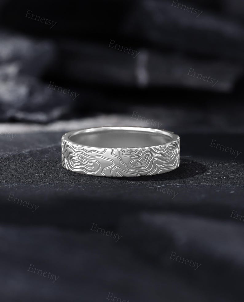 a close up of a wedding ring on a black surface