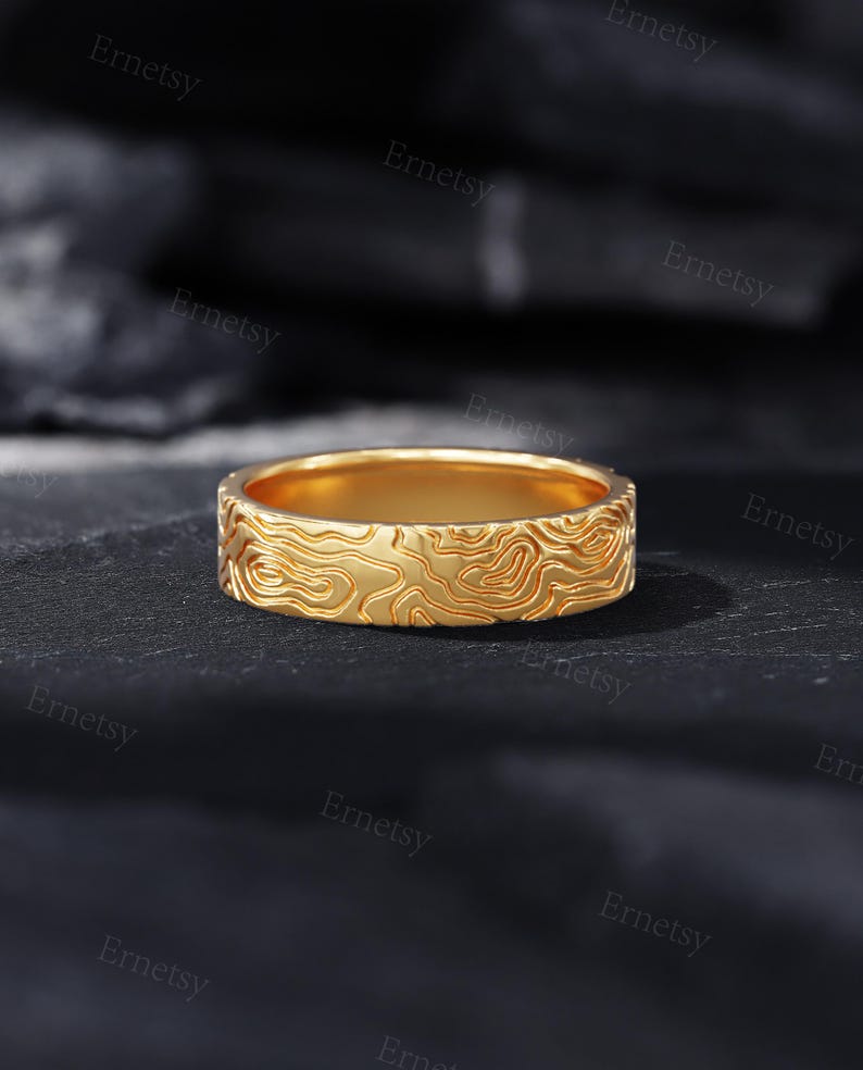 a close up of a gold ring on a black surface