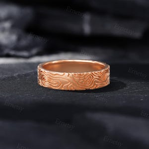 a wedding band with a carved design on it