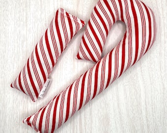 May include: Three red and white striped fabric candy canes and a small rectangular pillow. The candy canes are in different sizes and shapes. The small pillow has the text "The Three Twinkles" on a white tag.