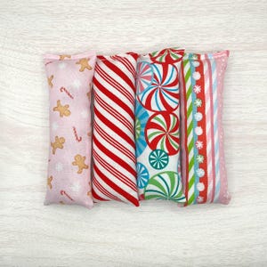 May include: Four festive catnip toys with different Christmas-themed patterns: gingerbread men, candy canes, peppermint swirls, and snowflakes. The toys are made of soft fabric and are perfect for cats to play with.