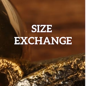 May include: A close-up of a gold-colored object with the text "SIZE EXCHANGE" in white letters.