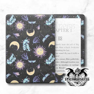 May include: A black and white Kindle e-reader with a custom cover featuring a repeating pattern of moons, suns, and dragonflies on a dark background. The text "Chapter 1" is visible on the screen.