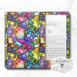 Peut inclure: Une illustration numérique colorée d'une liseuse Kindle avec une couverture présentant un motif répétitif de différents personnages de dessins animés, dont un fantôme, un papillon, un monstre et un vaisseau spatial. Le texte "Your Existence Matters" est répété tout au long du motif. La Kindle est ouverte à une page avec le texte "Chapitre 1" et un court extrait d'un livre.