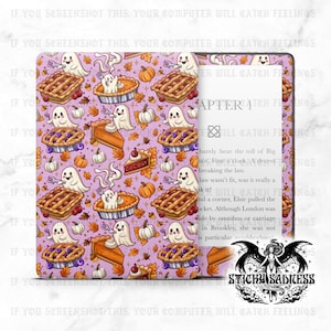 May include: A purple Kindle cover with a repeating pattern of cartoon ghosts, pies, pumpkins, and autumn leaves. The cover is open, revealing the device's screen with text. The design has a spooky, fall theme.