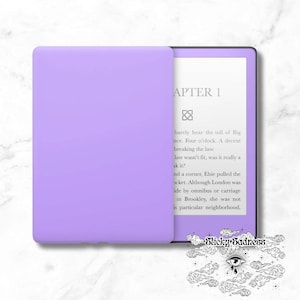 May include: A purple e-reader with a white cover. The screen displays the text "APTER 1" and a paragraph of text. The text on the screen reads: "barely hear the toll of Big nce. Four o'clock. A decent breaking the law. law wasn't fit, was it really a ak it? nd a corner, Elsie pulled the ocket. Although London was ide by omnibus or carriage in Brookley, she was not is particular neighborhood."