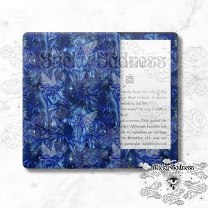May include: A blue and white patterned Kindle Paperwhite e-reader with a blue floral design. The text on the screen reads "barely hear the toll of Big Ben. Four o'clock. A decent breaking the law..."