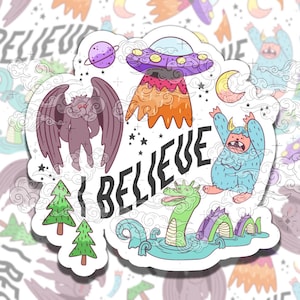 May include: A sticker with a colorful illustration of a monster, a flying saucer, a winged creature, a dragon, and two pine trees. The text "I BELIEVE" is written in black letters.