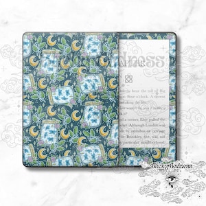 May include: A Kindle Paperwhite e-reader with a custom cover featuring a repeating pattern of blue butterflies in glass jars with yellow moons and green leaves on a dark blue background. The text "Sticky Sadness" is visible at the bottom of the image.