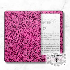 May include: A pink and black leopard print Kindle Paperwhite e-reader cover with the text "Sticky Sadness" and a stylized eye with clouds.