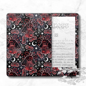 Peut inclure: Une peau noire et rouge pour liseuse Kindle Paperwhite avec un motif répété de papillons pixélisés, de manettes de jeu et d'étoiles. Le texte "PLAY" apparaît plusieurs fois sur la peau.