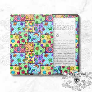 May include: A colorful digital reader cover with a patchwork design featuring peace signs, rainbows, flowers, and smiley faces. The cover is designed to fit a Kindle Paperwhite.
