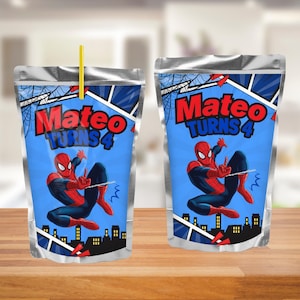 May include: Two silver foil drink pouches featuring a blue background with a graphic of the superhero Spider-Man, a city skyline, and the text "Mateo Turns 4" in red and blue letters. One pouch includes a thin yellow straw inserted at the top.