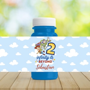 Op de afbeelding: Een blauwe bellenblaasfles met een witte dop. Het etiket toont de tekst "infinity & beyond" en het nummer "2" met stripfiguren. De achtergrond is lichtblauw met witte wolken. De naam "Sebastian" staat ook op het etiket.