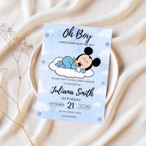 Puede incluir: Una invitación de baby shower azul con un dibujo animado de Mickey Mouse vestido con un pijama azul durmiendo en una nube. La invitación dice "¡Oh Boy! Un dulce bebé está en camino." e incluye el texto "Por favor, únase a nosotros para una baby shower en honor a Juliana Smith, sábado 21 de septiembre a las 2 PM, 123 Any Street 55555, RSVP123456789."