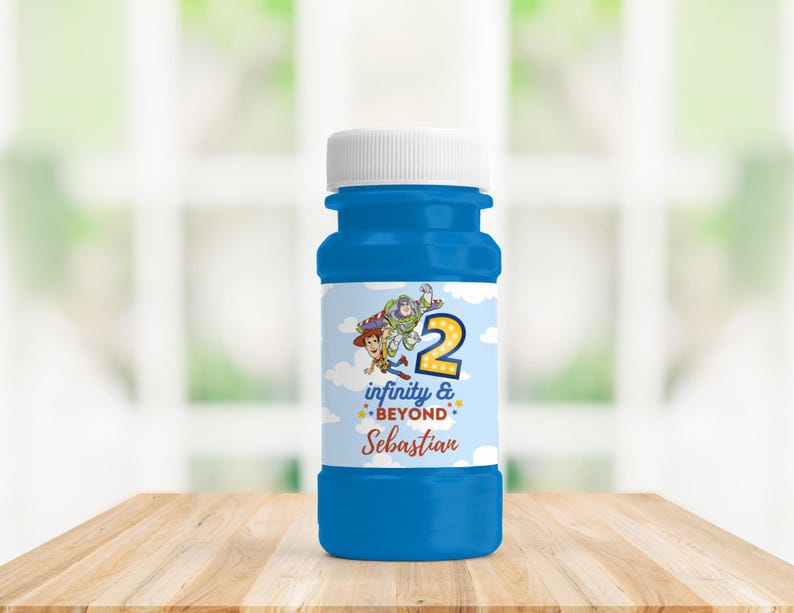 Op de afbeelding: Een blauwe bellenblaasfles met een witte dop. Het etiket toont de personages Woody en Buzz Lightyear, het nummer 2 en de woorden "infinity & beyond" en "Sebastian". De fles staat op een houten oppervlak.