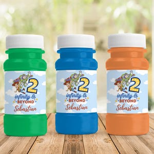 May include: Three colorful bubble bottles: green, blue, and orange. Each bottle has a white cap and a label featuring a cartoon image of Woody, Buzz Lightyear, and the number 2. The labels also read "infinity & beyond" and a name.