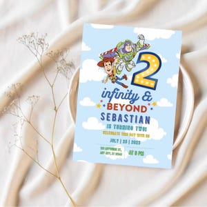 Könnte beinhalten: Eine blaue und weiße Geburtstagseinladung mit einem Cartoon-Bild von Woody und Buzz Lightyear aus Toy Story. Die Einladung lautet "infinity & beyond Sebastian wird zwei! Feiert diesen Tag mit uns am 25. Juli 2023 um 18 Uhr".