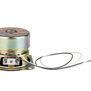 May include: A compact, circular speaker with a gold metallic finish. It features a square base and a cylindrical top. Black and white wires with a connector are attached. This speaker is designed for audio applications.