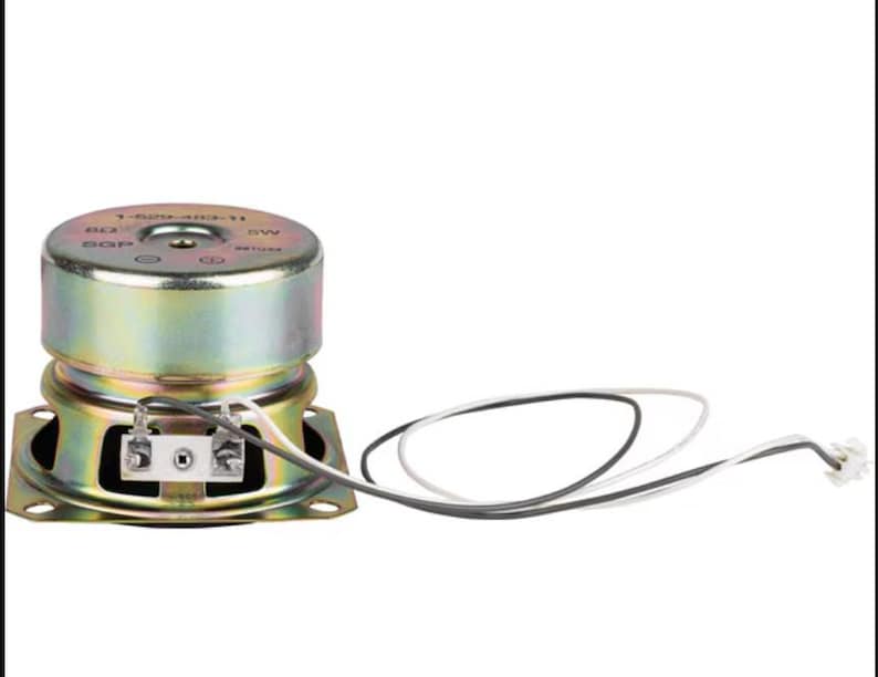 May include: A compact, circular speaker with a gold metallic finish. It features a square base and a cylindrical top. Black and white wires with a connector are attached. This speaker is designed for audio applications.