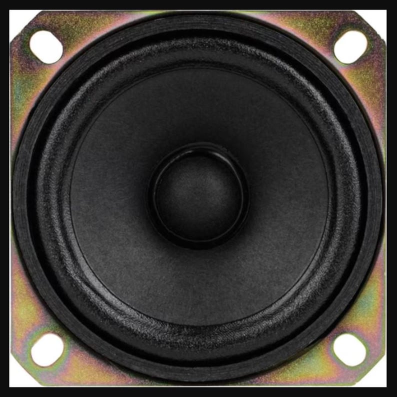 May include: A close-up shot of a small speaker. The speaker features a black cone and a black rubber surround, set within a square, gold-coloured metal frame with four mounting holes.