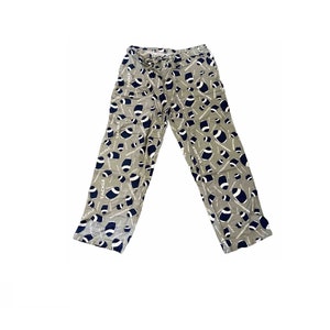 May include: Tan colored pajama pants with a pattern of blue footballs and the word "TACKLE" repeated throughout.