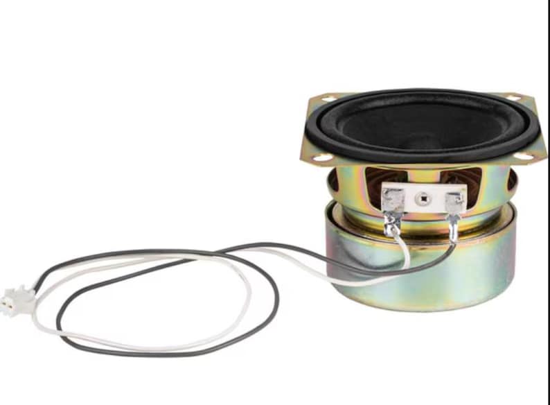 May include: A small, round speaker with a black cone and a metallic gold and silver frame. The speaker has a square mounting plate and attached wires with a connector. The speaker is designed for audio applications.