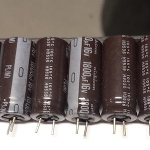 May include: Ten black cylindrical capacitors with silver labels. The labels read "1800 μF 16V" and "nichicon".