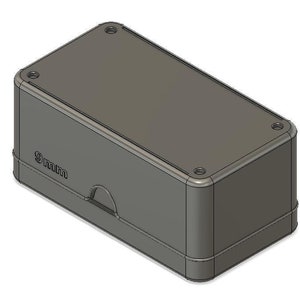 Könnte beinhalten: Eine graue rechteckige Box mit einem 9 mm Etikett an der Seite. Die Box hat eine kleine Öffnung an der Vorderseite.