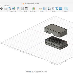 May include: A 3D rendering of a gray rectangular box with a lid, and a base with a grid pattern. The box is designed with a modern aesthetic, likely for storage or organization. The image is set against a grid background.