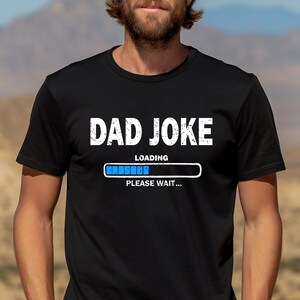 May include: Black t-shirt with white text that reads "DAD JOKE LOADING... PLEASE WAIT..." with a blue progress bar.