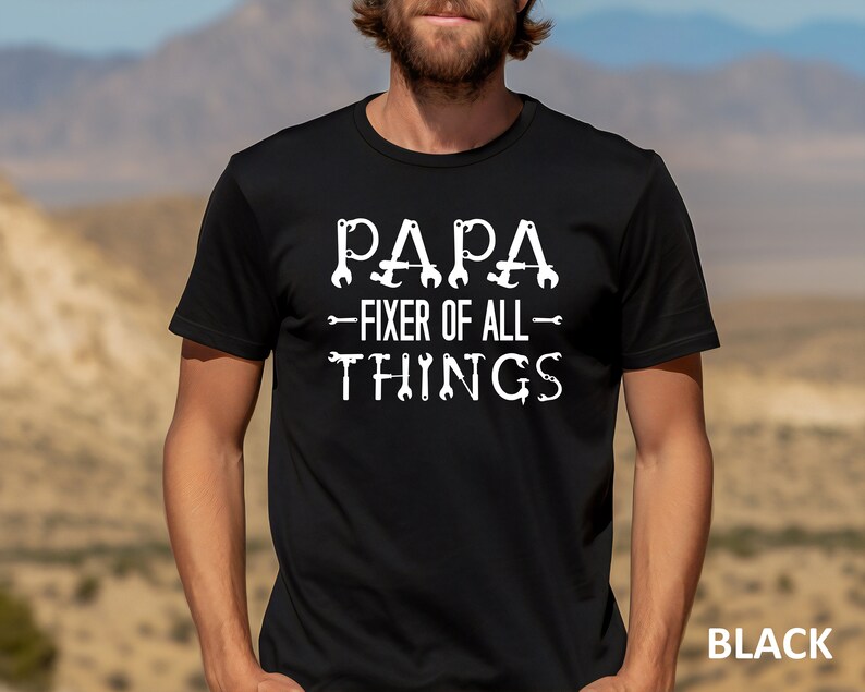 May include: Black t-shirt with white text that reads "Papa - Fixer of All - Things" with wrench and screwdriver graphics.