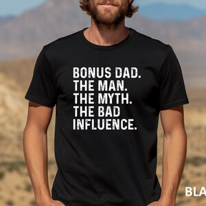 May include: Black t-shirt with white text that reads "Bonus Dad. The Man. The Myth. The Bad Influence."
