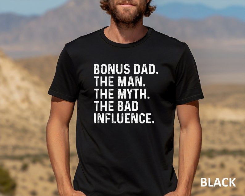 May include: Black t-shirt with white text that reads "Bonus Dad. The Man. The Myth. The Bad Influence."