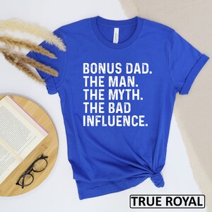 May include: Royal blue t-shirt with white text that reads "Bonus Dad. The Man. The Myth. The Bad Influence."